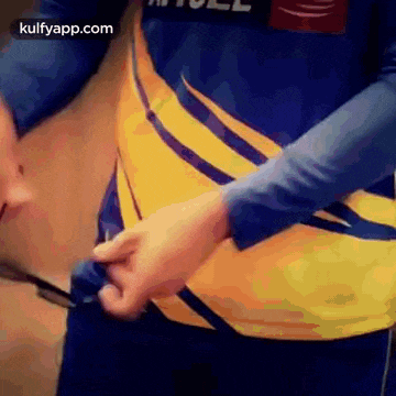 a person is wearing a yellow and blue shirt and a blue shirt .