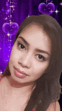 a close up of a woman 's face with purple hearts behind her