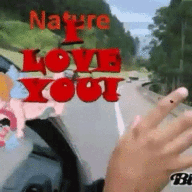 a person is driving down a highway with the words `` i love you '' on the side of the road .