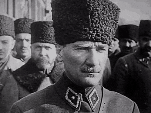 a black and white photo of a man wearing a fur hat and a mustache .