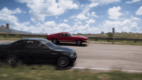 a red car is driving next to a black car on a highway