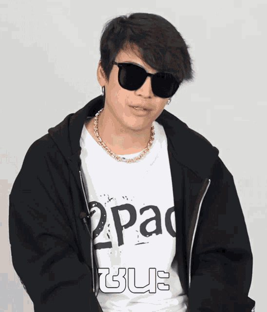 a young man wearing sunglasses and a 2pac shirt