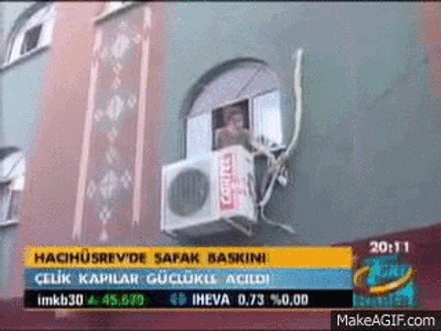 an air conditioner is hanging from the side of a building .