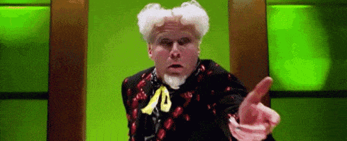 a man with white hair and a beard is pointing his finger at something .