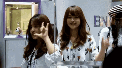 two girls are standing in front of a sign that says bnn