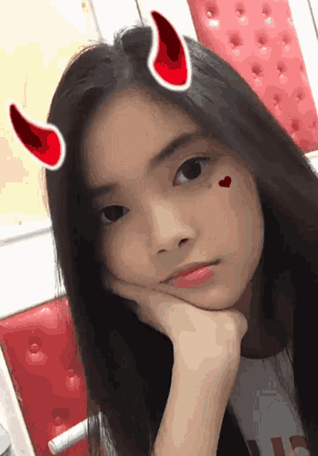 a girl with devil horns on her head and a heart on her face