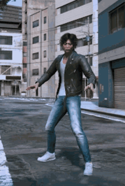 a man in a black leather jacket and jeans is standing on a street