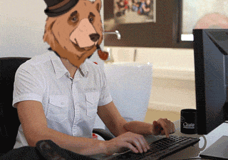 a man with a bear mask on his head is typing on a computer
