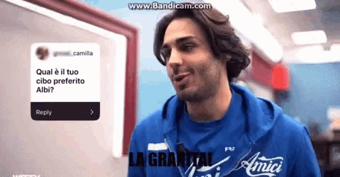 a man wearing a blue shirt that says amici