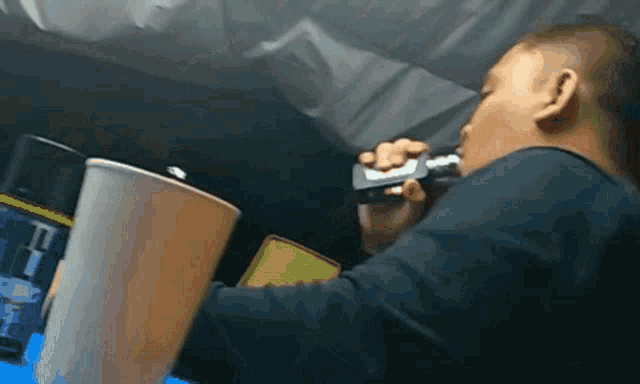 a man in a black shirt is smoking a cigarette