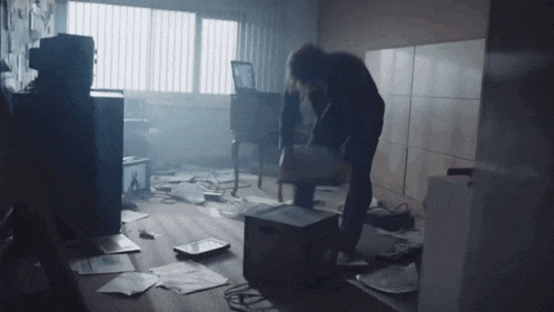a person is standing in a messy room with papers on the floor