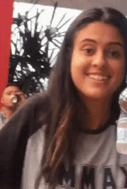 a woman wearing a shirt with the word mad on it smiles