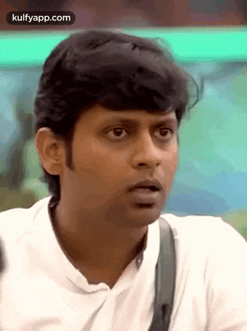 a man with a surprised look on his face is wearing a white shirt .