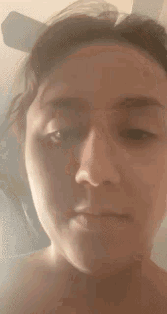 a close up of a woman 's face with a blurred background .