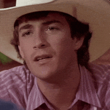 a close up of a man wearing a cowboy hat and striped shirt