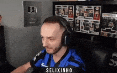 a man wearing headphones and a blue shirt with the name selixinho on the back