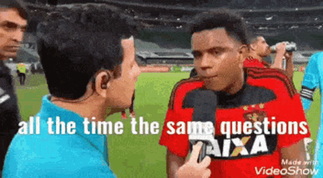 a man in a caixa shirt is talking to another man