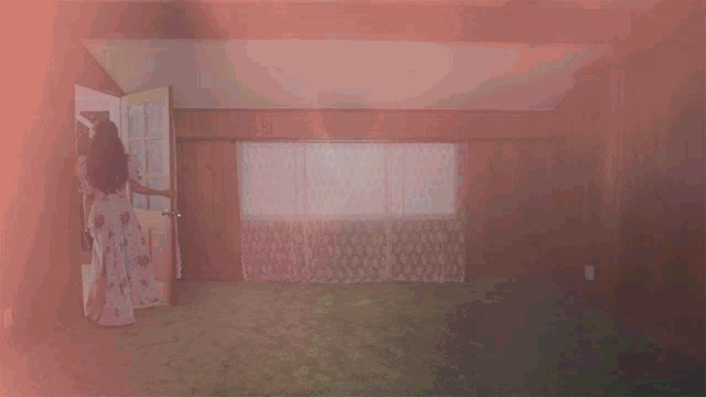 a woman in a floral dress stands in a room with wood paneling