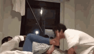 a man is kissing another man 's foot on a bed in a room .