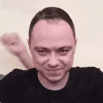 a close up of a man 's face with a fist in his hand .