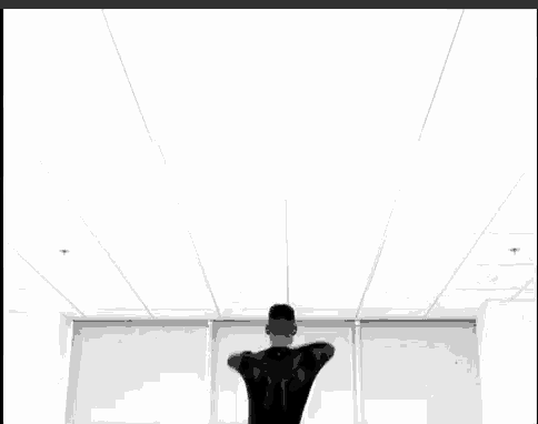 a man is standing in front of a window with his arms outstretched .