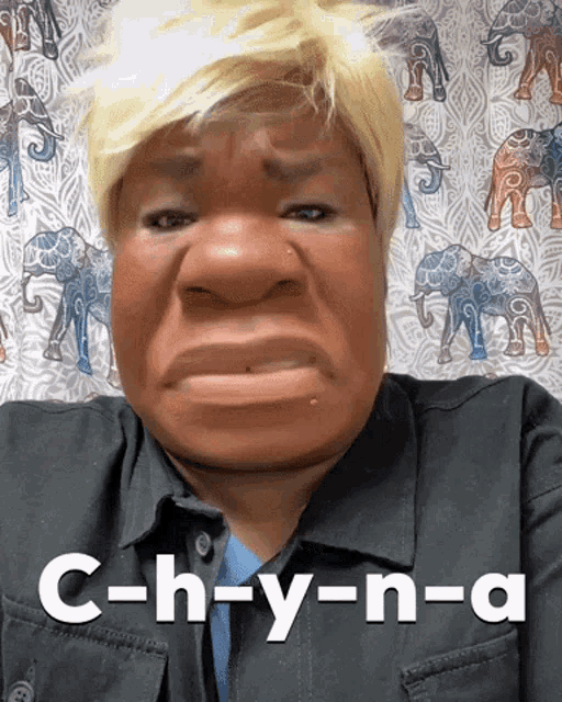 a woman wearing a wig says c-h-y-n-a on the bottom of her face