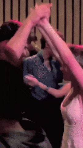 a group of people are dancing in a dark room