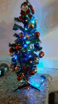 a small christmas tree with blue lights and red and silver ornaments