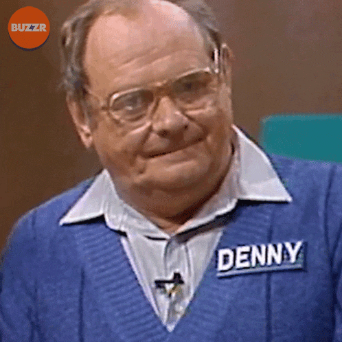 a man wearing glasses and a blue sweater with the name denny on it