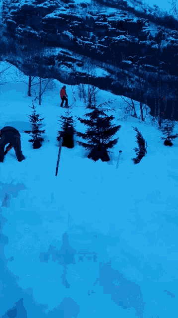 a man in an orange jacket is skiing down a snow covered slope