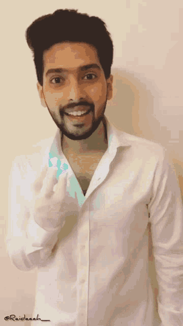 a man with a beard wearing a white shirt has the name raddash written on the bottom of his shirt