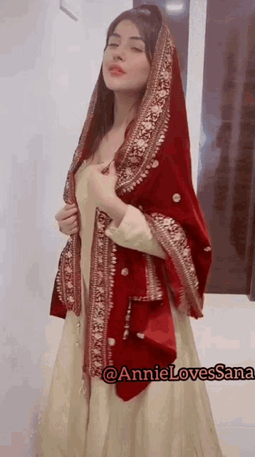 a woman wearing a white dress and a red scarf with the name annie lovessana