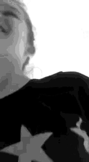 a black and white photo of a woman wearing a black sweater .