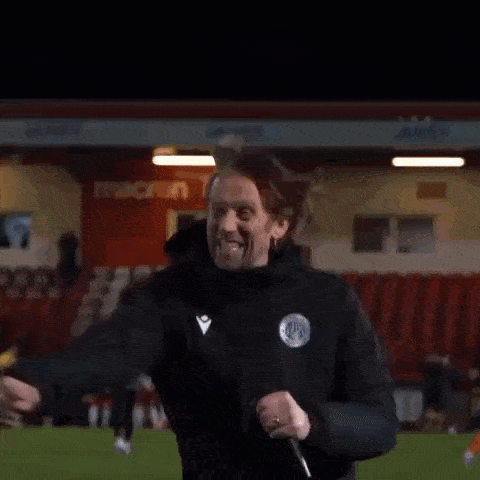 a man in a black jacket is screaming with his mouth open in the dark .