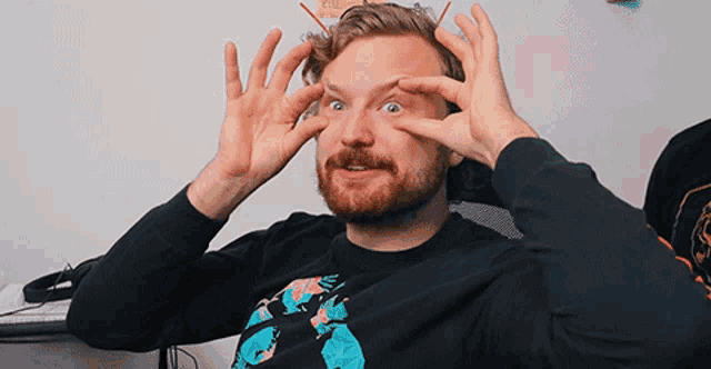 a man with a beard is wearing a black shirt with the number 5 on it