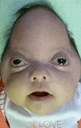 a close up of a baby 's face with a bib that says i love on it .