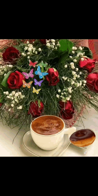 a cup of coffee is on a saucer next to a bouquet of flowers