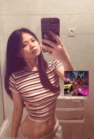 a woman is taking a selfie in a bathroom mirror with her phone .