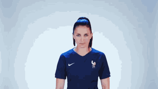a woman wearing a blue nike shirt with a french rooster on it