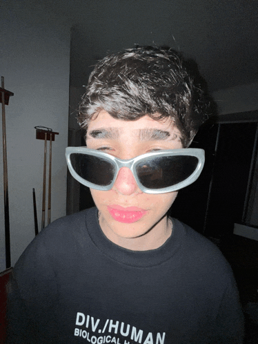 a person wearing sunglasses and a shirt that says div human biological