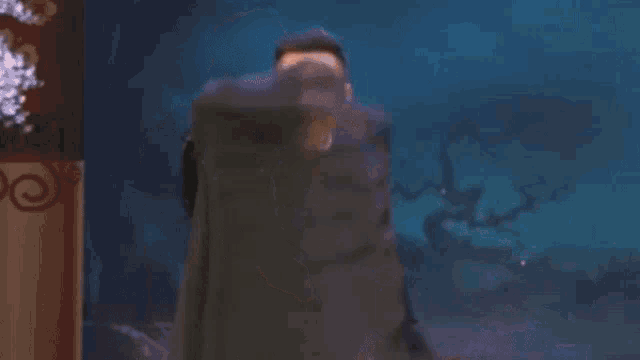a man in a black robe is standing on a stage holding a microphone and smiling .