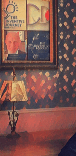 a lamp sits in front of a framed picture that says the inventive journey on it