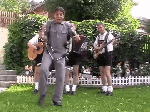a group of men are playing instruments in a backyard and one of them is holding an accordion .