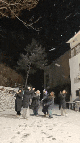 a group of people are standing in the snow with their arms outstretched