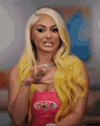 a woman with blonde hair is wearing a pink tank top and a yellow sweater .