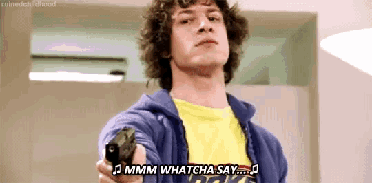 a man in a blue hoodie is pointing a gun at the camera with the words " mmmm whatcha say " below him