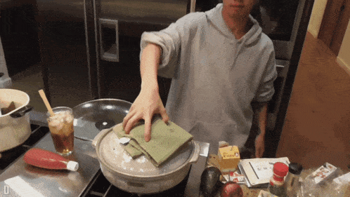 a person cooking in a kitchen with a carton of heinz ketchup