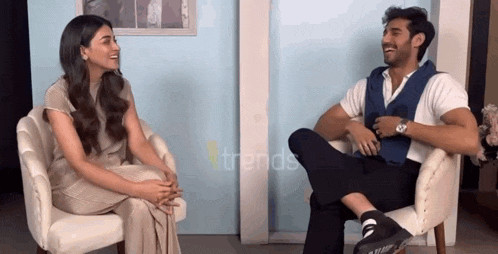 a man and a woman are sitting in chairs talking to each other