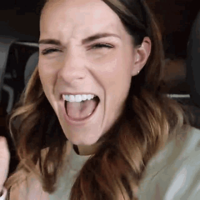 a close up of a woman making a funny face with her mouth open
