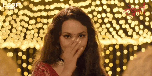 a woman covering her face with her hand in front of a sign that says loot india